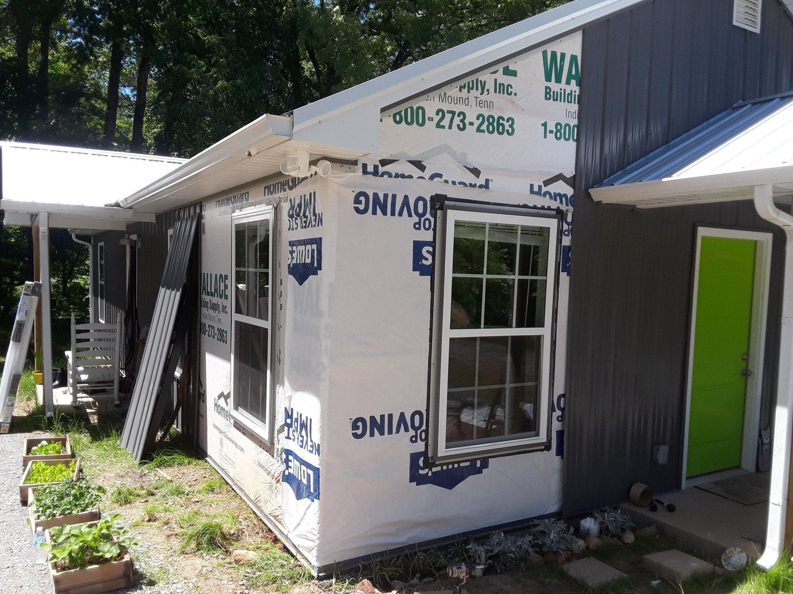 Home addition under construction with exterior framing and building wrap installation